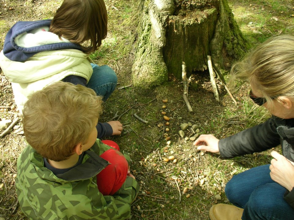 A group of young children sitting next to a tree