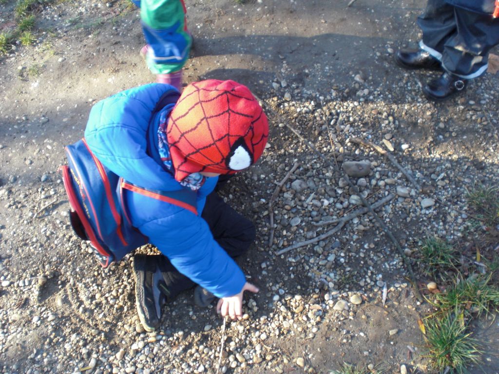 A little boy that is standing in the dirt