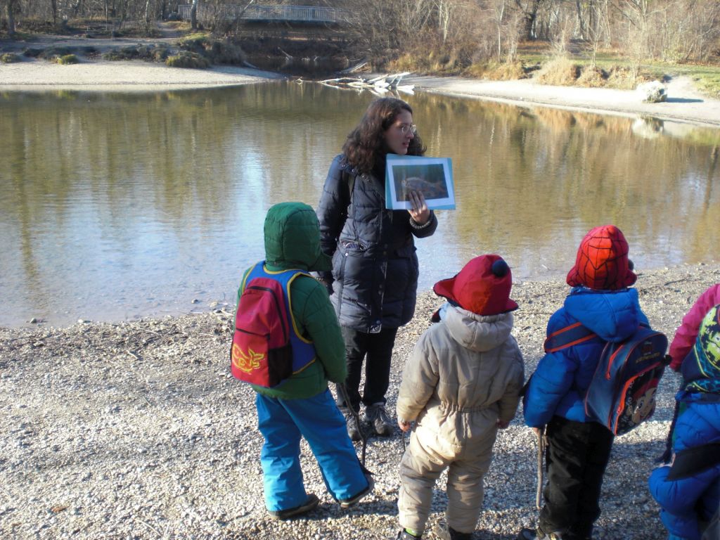 A group of people standing next to a body of water