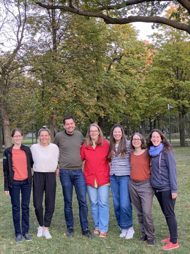 A group of people standing in front of a tree posing for the camera